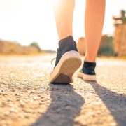Sneakers walking on a sunny road
